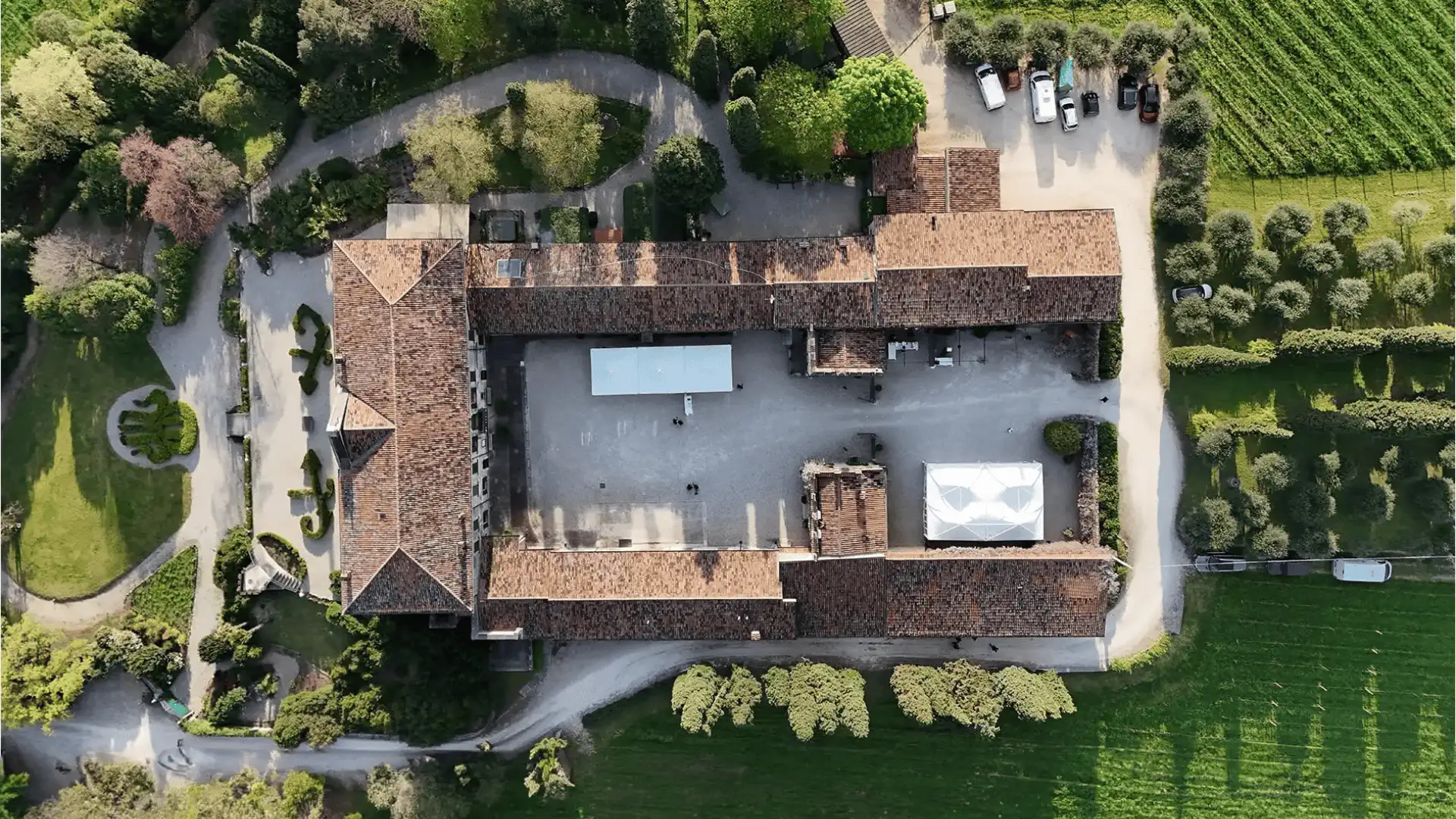 Vista aerea della corte interna della villa Marchesi Fumanelli, circondata da vigneti e giardini storici.
