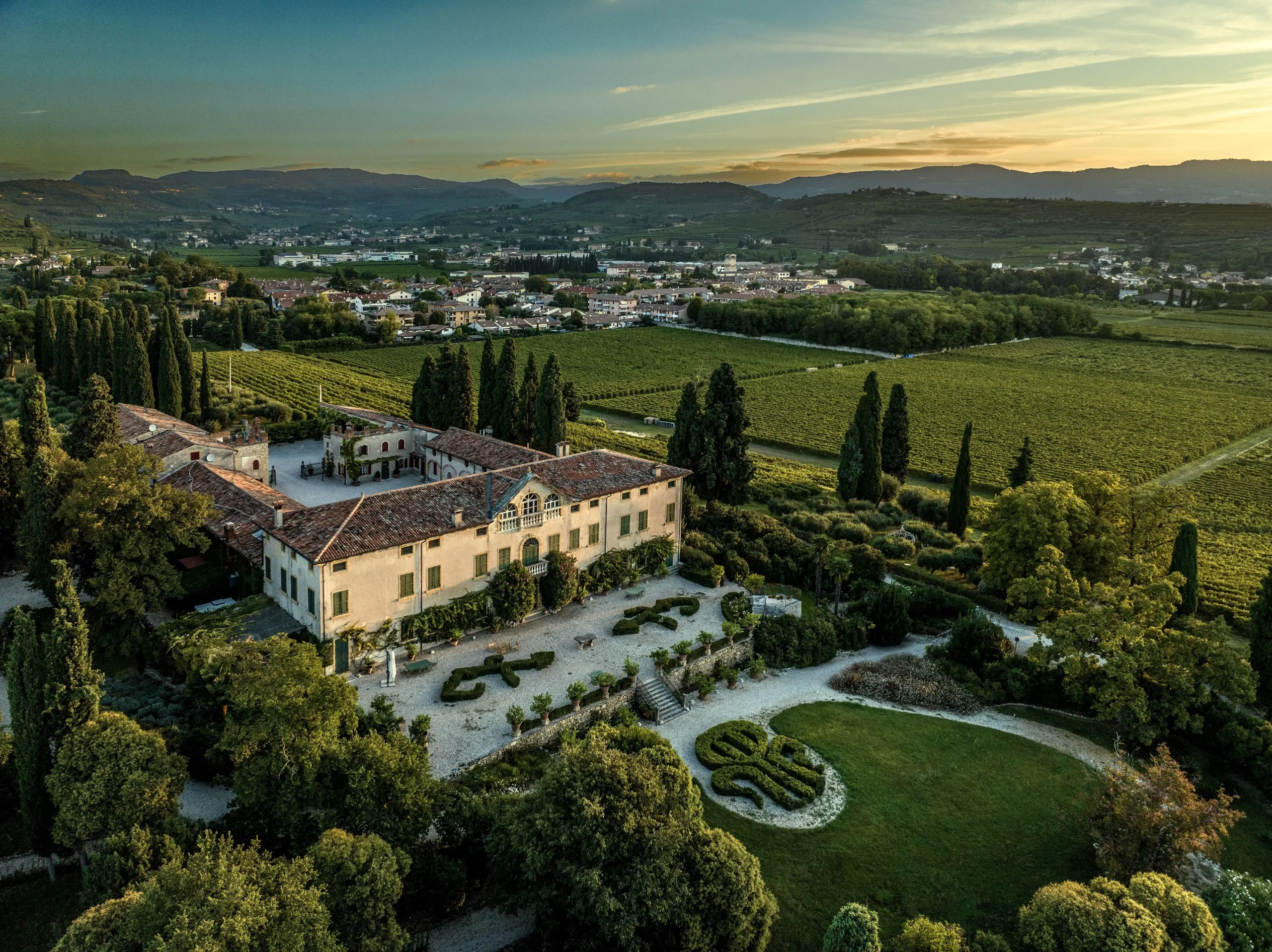 Villa Marchesi Fumanelli al tramonto con vigneti e colline della Valpolicella.