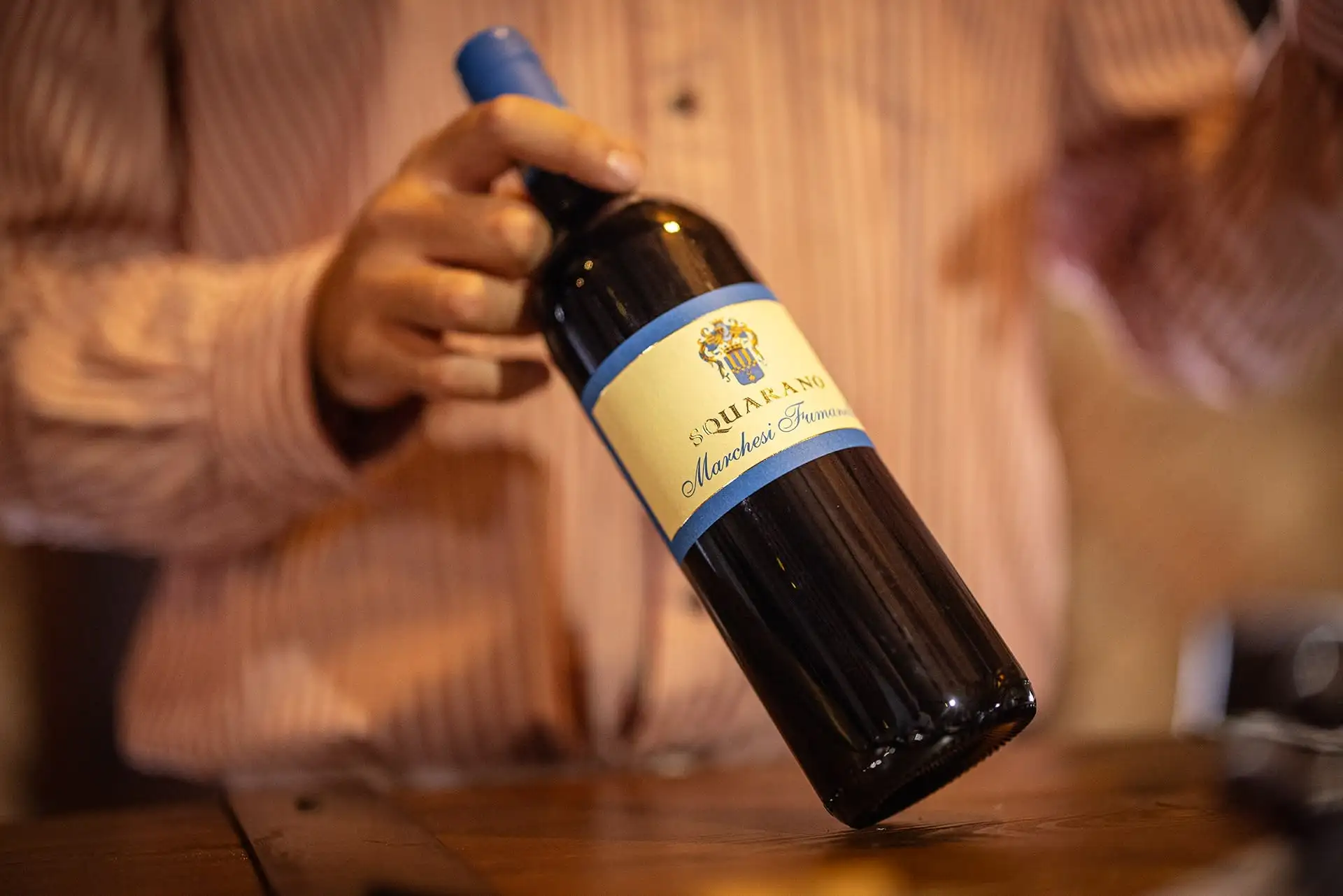 Bottiglia di Squarano Marchesi Fumanelli tenuta da un sommelier